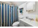 Clean bathroom with a blue-striped shower curtain, white sink, and a mirror at 1700 Laura Duncan Rd, Apex, NC 27502