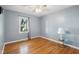 Bright bedroom with hardwood floors, neutral paint, and a large window at 1700 Laura Duncan Rd, Apex, NC 27502