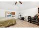 A bedroom with light walls, wood-look floors, a large bed, and lots of music gear at 1700 Laura Duncan Rd, Apex, NC 27502
