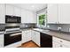 Charming kitchen featuring white cabinetry, gray backsplash, and modern appliances, creating a cozy culinary space at 1700 Laura Duncan Rd, Apex, NC 27502