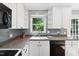 Kitchen with white cabinets, gray backsplash, dark countertops and a view to the exterior at 1700 Laura Duncan Rd, Apex, NC 27502