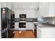 Modern kitchen featuring white cabinets, stainless steel appliances, gray backsplash, and hardwood flooring at 1700 Laura Duncan Rd, Apex, NC 27502