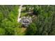 Gorgeous aerial view of a stately home surrounded by mature trees and a well-manicured lawn at 197 Boxwood Dr, Pittsboro, NC 27312