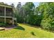 A serene backyard featuring a fireplace, green grass and mature trees providing a sense of privacy at 197 Boxwood Dr, Pittsboro, NC 27312