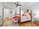 Bright bedroom featuring a four-poster bed, hardwood floors, and a ceiling fan at 197 Boxwood Dr, Pittsboro, NC 27312
