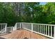 Wooden deck featuring white railings, wooden floors, and forest views at 197 Boxwood Dr, Pittsboro, NC 27312