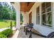 Inviting front porch with stone flooring, comfortable seating, and a charming wood-paneled ceiling at 197 Boxwood Dr, Pittsboro, NC 27312