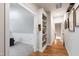Hallway with hardwood floors, white walls and trim, and built in bookshelves lead to carpeted room at 197 Boxwood Dr, Pittsboro, NC 27312