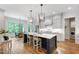 Bright, open kitchen with a large island, pendant lighting, stainless appliances, and hardwood floors at 197 Boxwood Dr, Pittsboro, NC 27312
