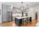 Modern kitchen featuring stainless steel appliances, a central island with seating, and elegant pendant lighting at 197 Boxwood Dr, Pittsboro, NC 27312