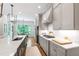 Bright kitchen featuring gray cabinets, an island with a sink, and hardwood floors with an adjacent breakfast nook at 197 Boxwood Dr, Pittsboro, NC 27312
