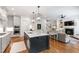Open concept kitchen with an island, stainless steel appliances, and hardwood floors, flowing into living area at 197 Boxwood Dr, Pittsboro, NC 27312