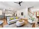 Bright living room featuring a sofa, hardwood floors, with access to a modern kitchen and staircase at 197 Boxwood Dr, Pittsboro, NC 27312