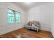 Bright sitting room features wood floors, white wainscotting, and a window overlooking the trees at 197 Boxwood Dr, Pittsboro, NC 27312