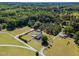Wide aerial shot of a property with a house, pool, sheds, long driveway, and surrounding forested landscape at 198 Fore View Ln, Sanford, NC 27332