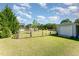 Spacious backyard showcasing lush lawn, shed, playground, and mature trees, ideal for outdoor activities at 198 Fore View Ln, Sanford, NC 27332
