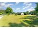 Well-manicured property with large front lawn and mature trees, featuring a house, shed and long driveway at 198 Fore View Ln, Sanford, NC 27332