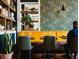 A vibrant dining area featuring patterned wallpaper, cozy booth seating, and stylish decor with a snake plant at 210 Byrum St # 6, Cary, NC 27511