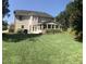 Expansive backyard showcasing a lush green lawn, screened porch, and rear exterior of the home at 210 Shillings Chase Dr, Cary, NC 27518