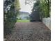 View of a large green backyard with a home in the distance and a wooden fence to the right at 210 Shillings Chase Dr, Cary, NC 27518