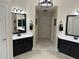 Symmetrical bathroom featuring dual vanities with dark cabinetry and neutral tile flooring at 210 Shillings Chase Dr, Cary, NC 27518