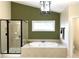 Bright bathroom featuring a large soaking tub with decorative tile surround and glass-enclosed shower at 210 Shillings Chase Dr, Cary, NC 27518