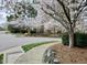 Community entrance with a brick sign surrounded by mature trees and blossoming white trees at 210 Shillings Chase Dr, Cary, NC 27518