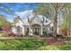 A bright white home with elegant columns is adorned with landscaped flower beds, and green lawn at 210 Shillings Chase Dr, Cary, NC 27518