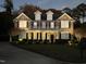 Beautiful brick home with well lit front yard and landscaping at dusk at 210 Shillings Chase Dr, Cary, NC 27518