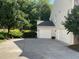 A large driveway leads to the two-car garage of this light beige home, surrounded by lush landscaping at 210 Shillings Chase Dr, Cary, NC 27518