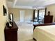 Spacious main bedroom boasts neutral walls, tray ceiling, and seating area near a bright window at 210 Shillings Chase Dr, Cary, NC 27518