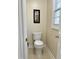Compact toilet room featuring a white toilet and a window for natural light at 210 Shillings Chase Dr, Cary, NC 27518