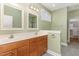 Bathroom boasts dual sinks, wood cabinets, gray tile floors and walk in closet at 2205 Karns Pl, Raleigh, NC 27614