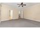 Spacious bedroom featuring neutral carpet, cream-colored walls, ceiling fan, and doorway to hallway at 2205 Karns Pl, Raleigh, NC 27614