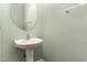Cozy powder room with pedestal sink, an oval mirror, and light green walls at 2205 Karns Pl, Raleigh, NC 27614
