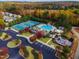 Aerial view of the community pool, playground, and tennis courts surrounded by colorful fall foliage at 2305 Everstone Rd, Wake Forest, NC 27587