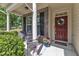 Inviting front porch with brick accents, seating, potted flowers, and a welcoming wreath on the front door at 2305 Everstone Rd, Wake Forest, NC 27587