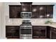 A kitchen boasting dark wood cabinets, stainless steel appliances, and granite countertops at 2305 Everstone Rd, Wake Forest, NC 27587