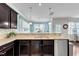 Sleek kitchen boasts granite countertops, stainless appliances, and dark wood cabinets with views to the backyard at 2305 Everstone Rd, Wake Forest, NC 27587