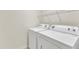 Laundry room featuring a white washer and dryer, and a wire shelf for storage at 2305 Everstone Rd, Wake Forest, NC 27587