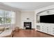 Cozy living room with a fireplace, large windows, and a built-in media center for storage and entertainment at 2305 Everstone Rd, Wake Forest, NC 27587