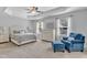 Main bedroom suite features a tray ceiling, a bed, an armchair, and large windows at 2305 Everstone Rd, Wake Forest, NC 27587