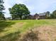 Large backyard featuring lush green grass and mature trees, perfect for outdoor activities at 235 Stephenson Rd, Benson, NC 27504
