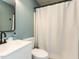 Bathroom featuring white fixtures, modern black hardware, and shower with a curtain rod at 235 Stephenson Rd, Benson, NC 27504