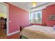 Bright bedroom with large window offering outdoor views, complemented by wood floors and soft pink walls at 2410 Environ Way, Chapel Hill, NC 27517