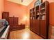 Cozy den with hardwood floors, an upright piano, and wood built-in storage and display shelving at 2410 Environ Way, Chapel Hill, NC 27517
