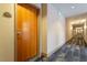 Hallway with wood door leading to a unit with patterned carpet and neutral walls at 2410 Environ Way, Chapel Hill, NC 27517