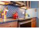 Modern kitchen with granite counters, glass cooktop, stainless appliances, and tile backsplash at 2410 Environ Way, Chapel Hill, NC 27517