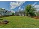 This backyard features a large manicured grassy area and firepit at 2412 Chartwell Ln, Graham, NC 27253
