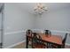 Cozy dining room with a wooden table, four chairs, and a charming chandelier for intimate meals at 2412 Chartwell Ln, Graham, NC 27253